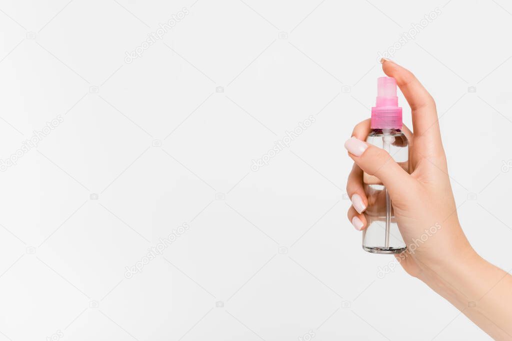 cropped view of woman holding spray bottle with aromatic liquid in hand isolated on white