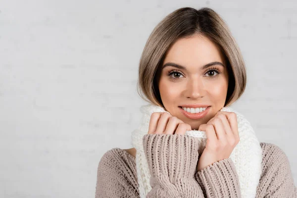 Young Woman Sweater Smiling Camera While Holding Scarf White Background — Stock Photo, Image