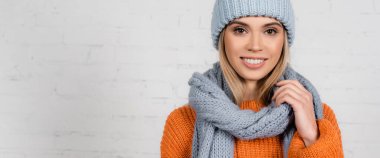 Smiling woman in warm hat, sweater and scarf on white background, banner  clipart