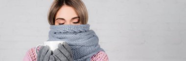 Beyaz arka planda eşarplı ve eldivenli genç bir kadın. 