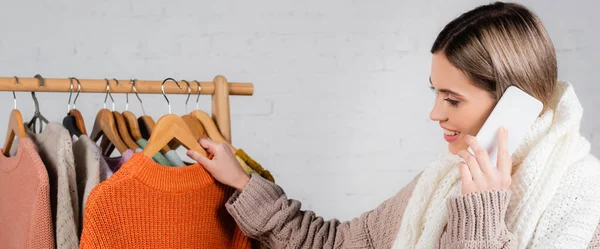 Cheerful Woman Talking Cellphone Holding Knitted Sweater White Background Banner — Stock Photo, Image