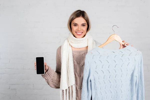 Young Woman Scarf Holding Smartphone Blank Screen Sweater Hanger White — Stock Photo, Image