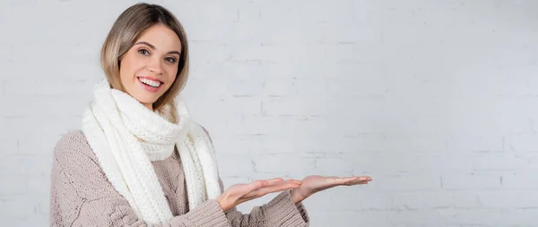 Junge Frau Pullover Und Schal Zeigt Mit Den Händen Auf — Stockfoto