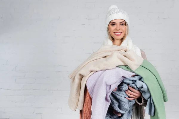 Mujer Alegre Sombrero Sosteniendo Suéteres Calientes Sobre Fondo Blanco — Foto de Stock