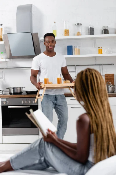 Smiling African Man Holding Tray Tasty Breakfast Girlfriend Book Bed — Stock Photo, Image