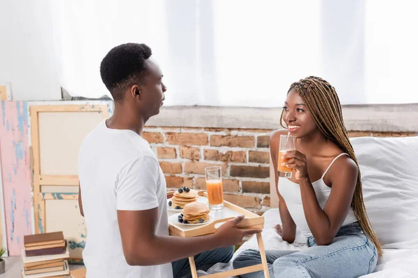 Smiling African American Woman Holding Glass Orange Juice Boyfriend Pancakes — Stock Photo, Image