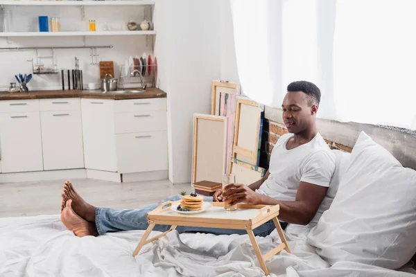 Smiling African American Man Holding Glass Orange Juice Pancakes Bed — Stock Photo, Image