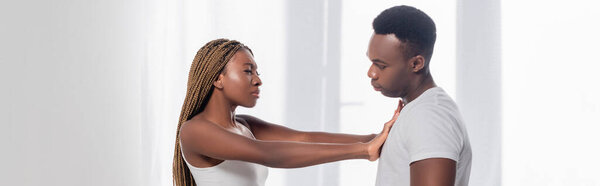 African american woman pushing back boyfriend while quarreling at home, banner