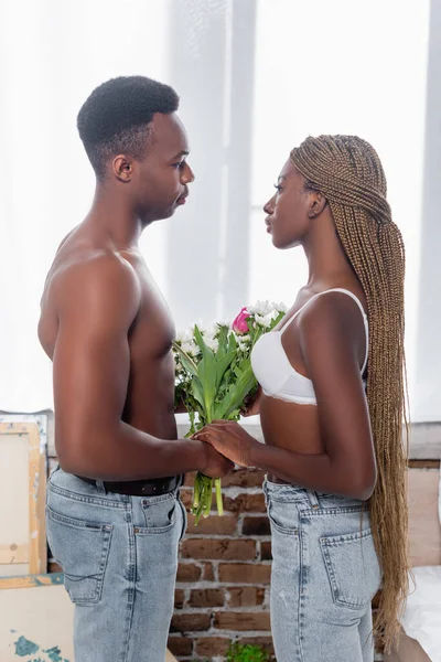 Seitenansicht Einer Afroamerikanerin Die Blumen Von Ihrem Hemdlosen Freund Nimmt — Stockfoto