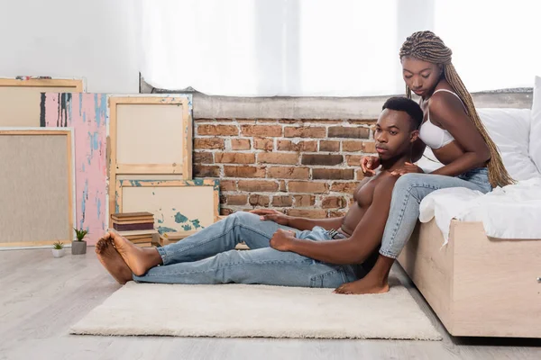 Seductive African American Woman Bra Touching Muscular Boyfriend Sitting Carpet — Stock Photo, Image
