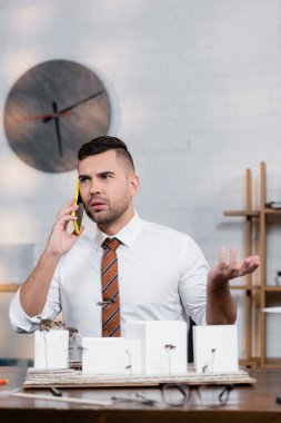 Mimari projenin yakınında akıllı telefonda konuşurken ciddi mimar hareketleri, bulanık önplan