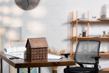 building maquette and models of wind turbines on desk near office chair clipart