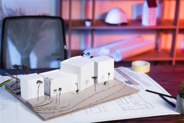 constructions models near blueprint on desk in architectural bureau clipart