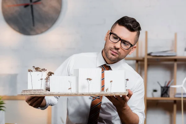 Sério Arquiteto Segurando Casas Modelos Escritório Arquitetura — Fotografia de Stock