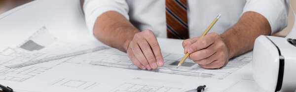 partial view of architect drawing on blueprint with pencil and ruler near vr headset, banner