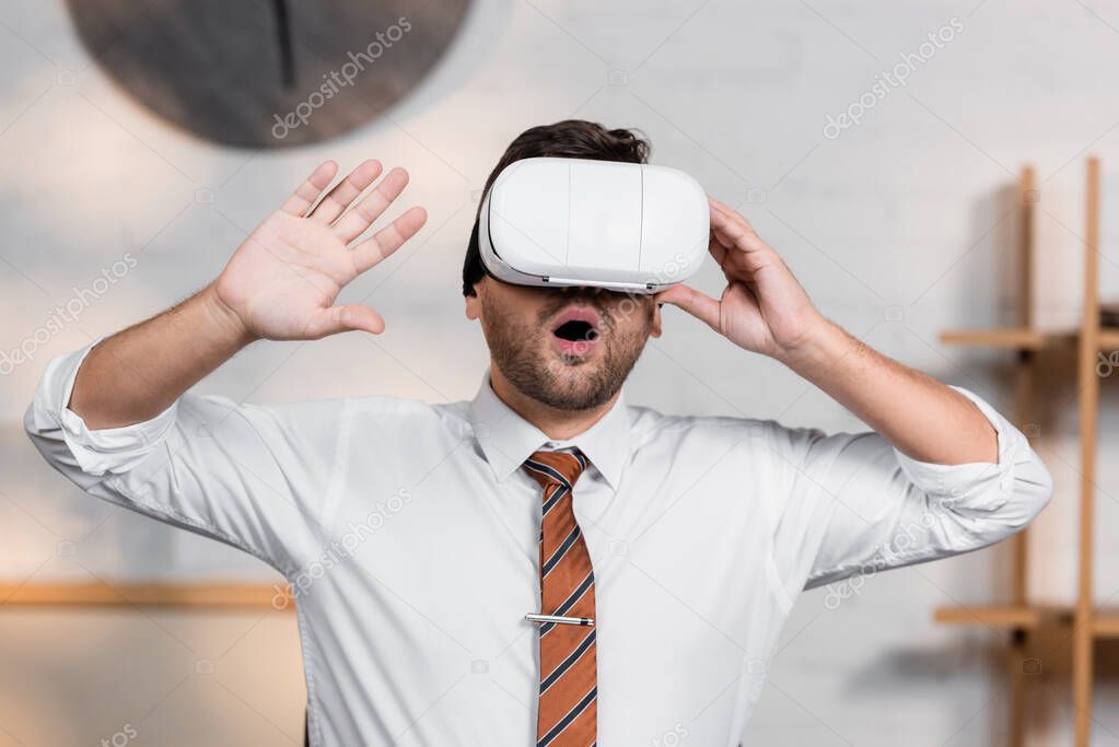 astonished architect gesturing while using vr headset in office