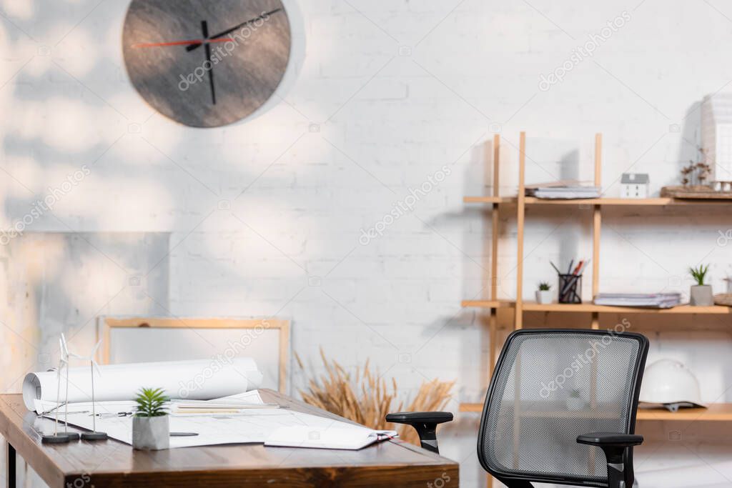 desk with blueprints and wind turbines models in architectural bureau