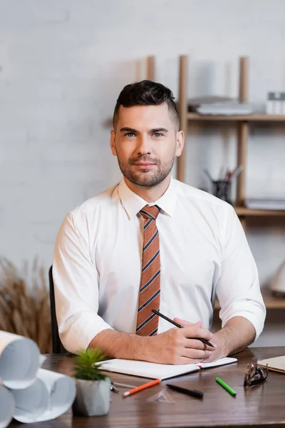 Architect Looking Camera While Sitting Workplace Notebook Rolled Blueprints — Stock Photo, Image