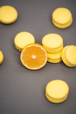 Gri arka planda sulu limonun yarısına yakın lezzetli sarı badem kurabiyelerinin yüksek açılı görüntüsü
