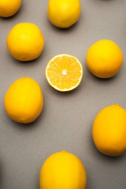 Gri arkaplanda sulu ve sarı limonların yüksek açılı görüntüsü