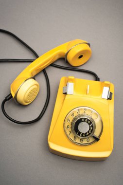top view of retro and yellow telephone on grey background clipart