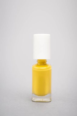 bottle with yellow nail polish on grey background  clipart