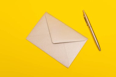top view of envelope near golden pen isolated on yellow clipart