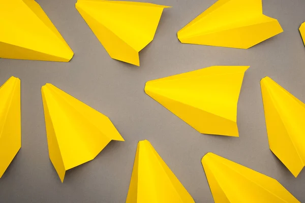 Gri Arkaplanda Sarı Kağıt Uçakların Üst Görüntüsü — Stok fotoğraf