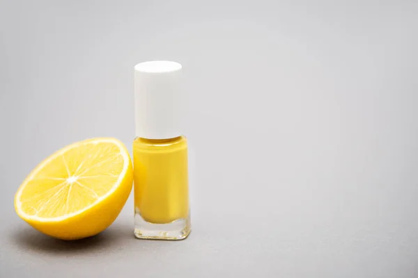 Bottle Yellow Nail Polish Half Lemon Grey Background — Stock Photo, Image