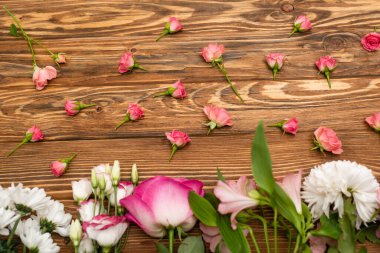 top view of variety of pink and white flowers on wooden surface clipart