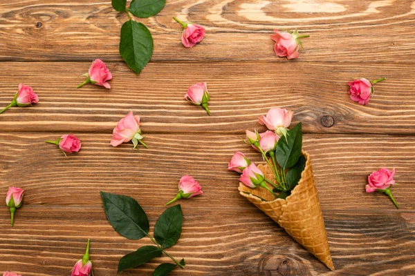Waffle Külahındaki Pembe Çay Güllerinin Ahşap Yüzeydeki Çiçeklerin Yanındaki Manzarası — Stok fotoğraf