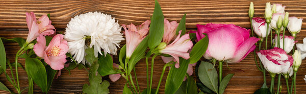 top view of variety of pink and white flowers on wooden surface, banner