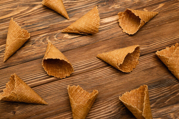 high angle view of tasty waffle cones on wooden surface 