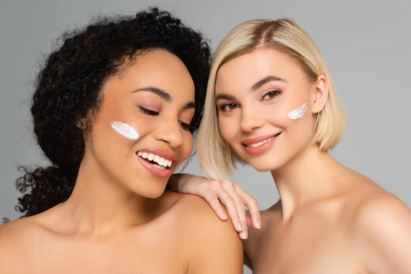 Smiling Multicultural Women Cosmetic Cream Cheeks Isolated Grey — Stock Photo, Image