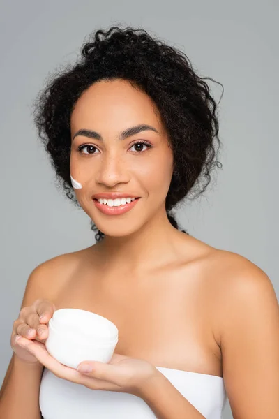 アフリカ系アメリカ人女性笑顔ながら保持瓶とともに化粧品クリーム隔離オングレー — ストック写真