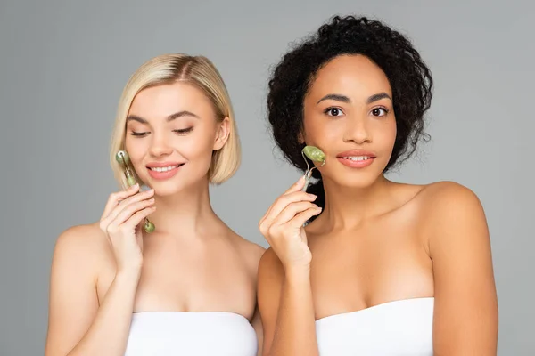 Mujeres Multiculturales Sonriendo Mientras Usan Rodillos Jade Aislados Gris — Foto de Stock