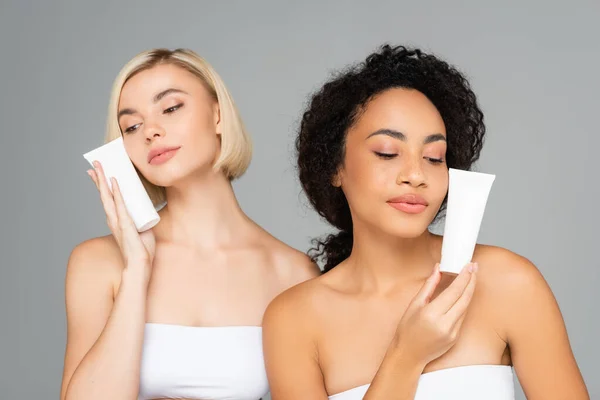 Young Multiethnic Women Holding Tubes Cleansing Foam Isolated Grey — Stock Photo, Image