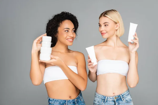 Multiethnic Women Smiling Each Other Holding Jars Tubes Moisturizing Cream — Stock Photo, Image