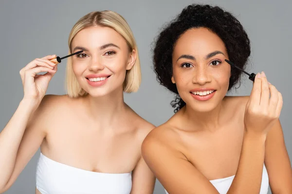 Mulheres Multiétnicas Sorridentes Aplicando Rímel Isolado Cinza — Fotografia de Stock