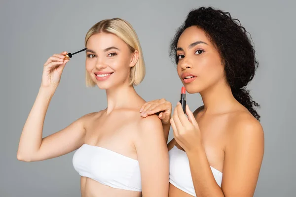 Mujeres Multiétnicas Sosteniendo Lápiz Labial Rímel Aislados Gris — Foto de Stock