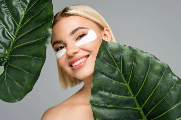 Jonge Vrouw Met Oogvlekken Glimlachend Buurt Van Groene Bladeren Geïsoleerd — Stockfoto