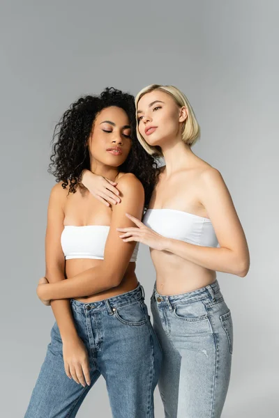 Blonde Woman Embracing African American Woman Jeans Grey Background — Stock Photo, Image