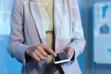 İşkadını, boş ekranlı akıllı telefonu işaret ederken kısmi görünüm 