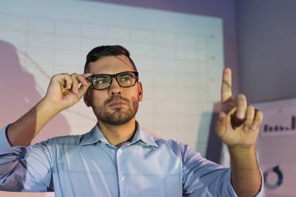 Geschäftsmann Mit Brille Zeigt Mit Finger Auf Verschwommenen Vordergrund — Stockfoto