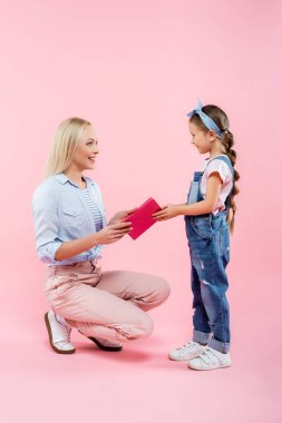 Mutlu anne pembe kızından tebrik kartı alıyor.