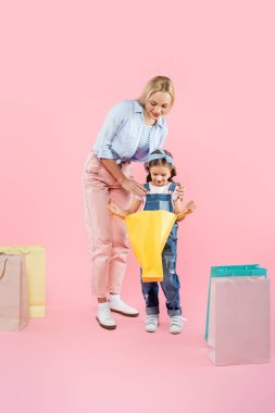 Mutlu bir anne-kız olarak pembe bir alışveriş çantasına bakıyoruz.