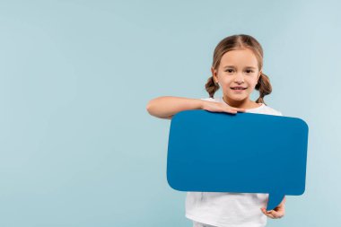 Konuşma baloncuğu tutan mutlu çocuk mavi üzerine izole