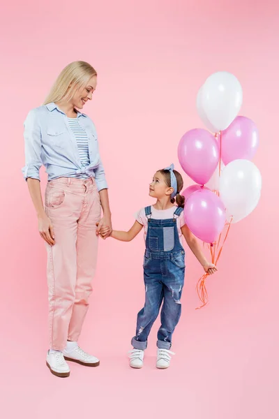 全身上下都是快乐的孩子 拿着气球 站在粉色的妈妈身边 — 图库照片