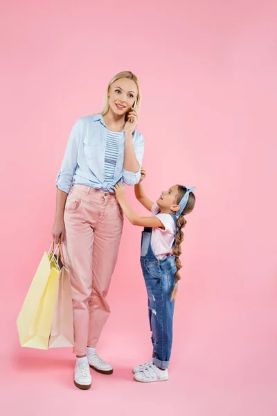 Full Length Mother Holding Shopping Bags Talking Smartphone Daughter Pink — Stock Photo, Image