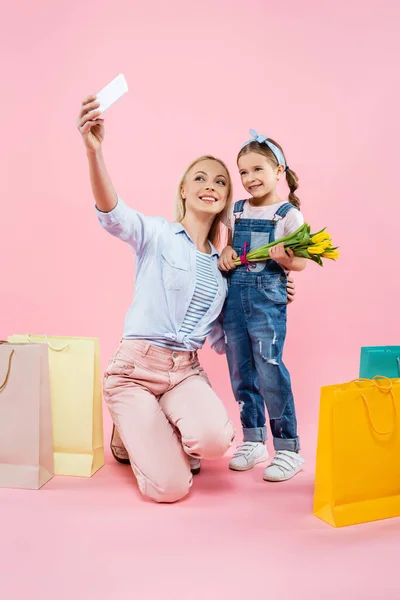 Mother Taking Selfie Cheerful Daughter Holding Tulips Shopping Bags Pink — Stock Photo, Image